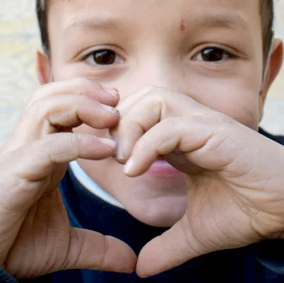 Child making a heart gesture