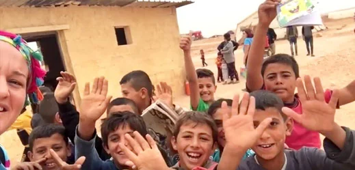 أطفال يلوحون للكاميرا