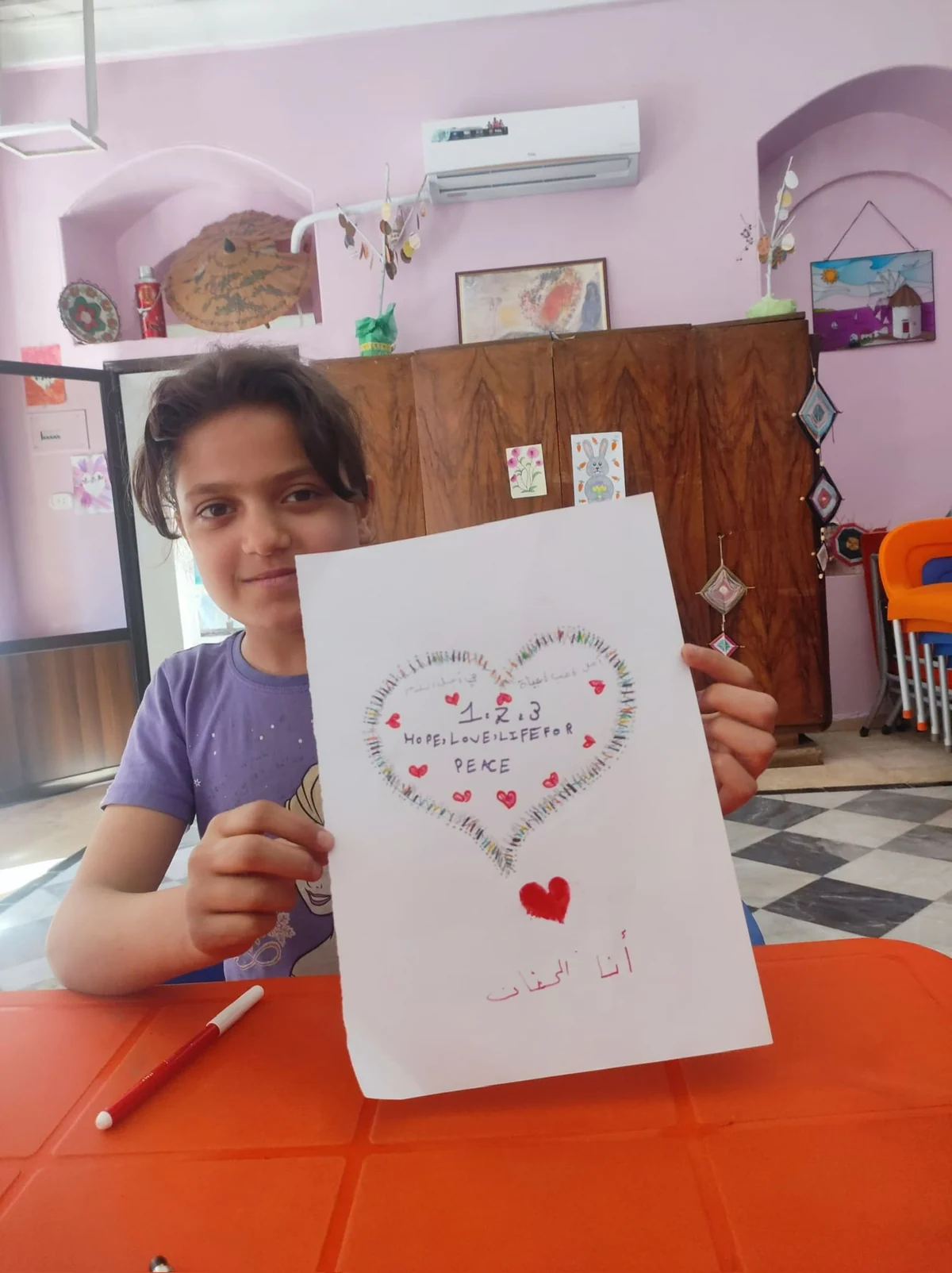 Enfant montrant un dessin pour la paix.