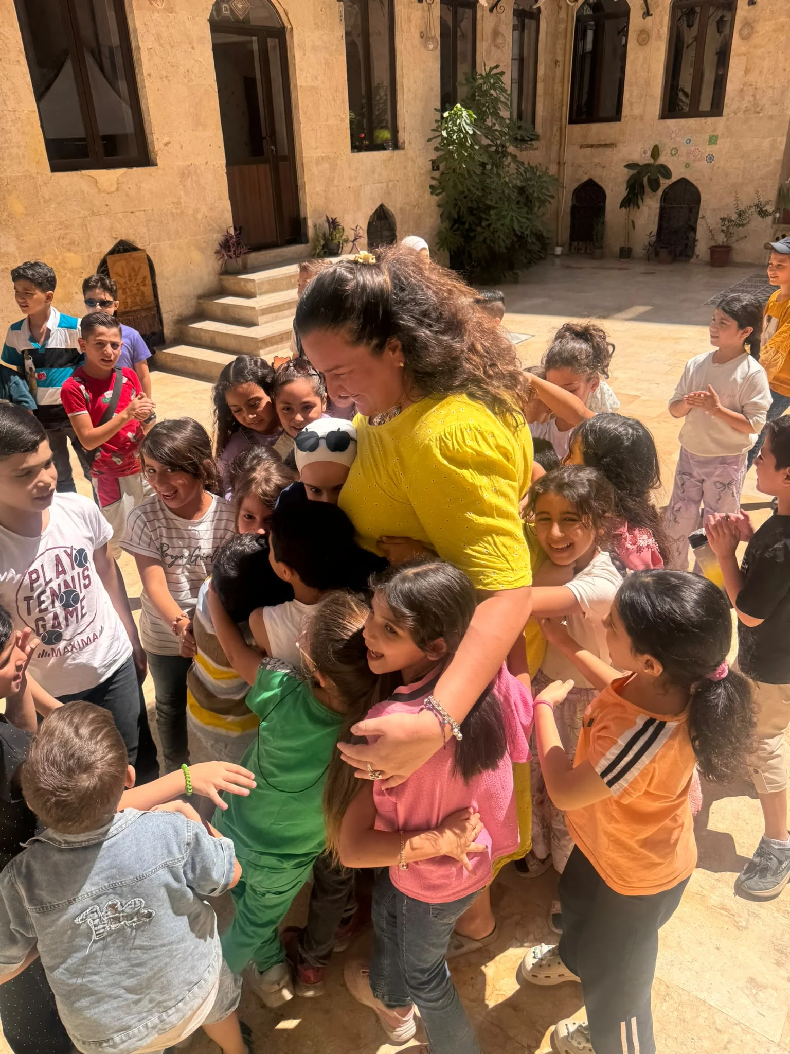 Soumaya Hallak entourée d’enfants dans la cour du centre 123 HOPE à Alep.